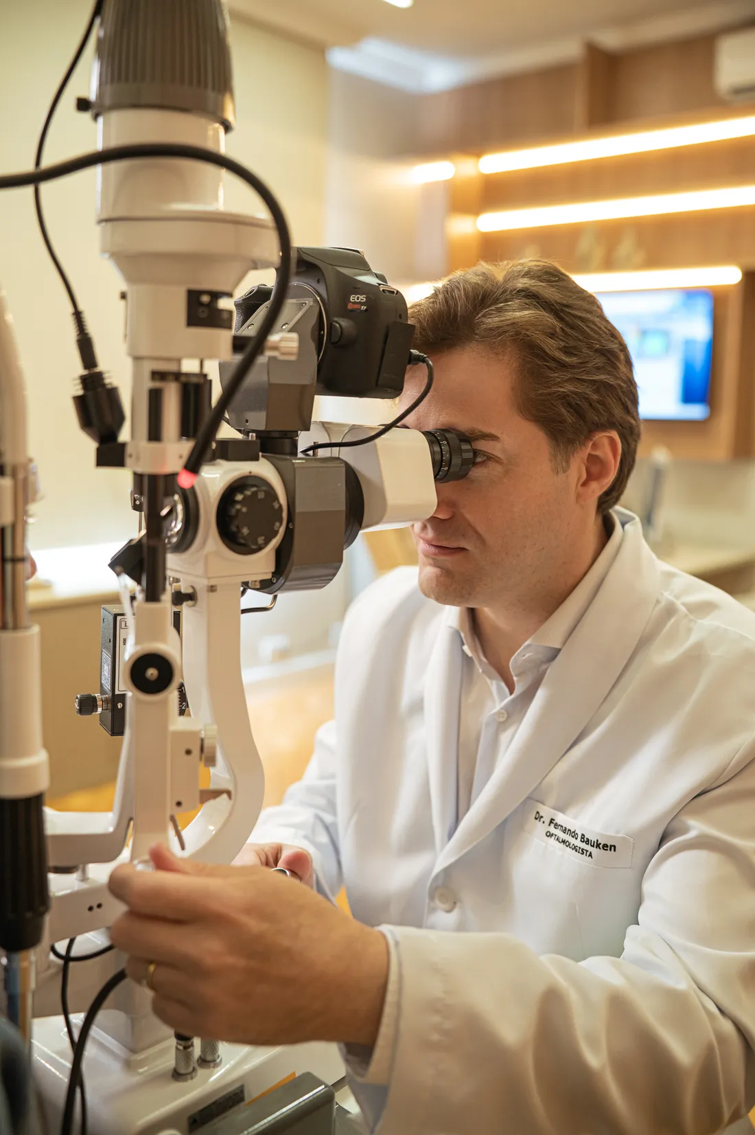 Dr. Fernando Bauken examinando no aparelho de lâmpada de fenda